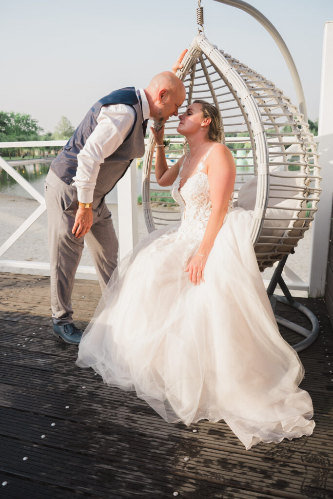 Trouwen bij Beachclub Degreez bruidspaar in de hangstoel op het strand